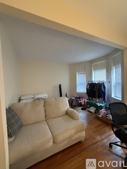 A living room with a beige couch and a black chair.