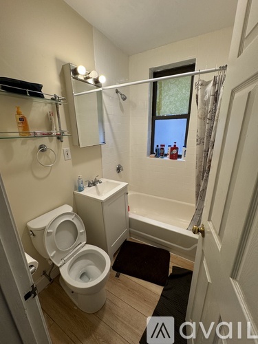 A bathroom with a toilet, sink, and bathtub.