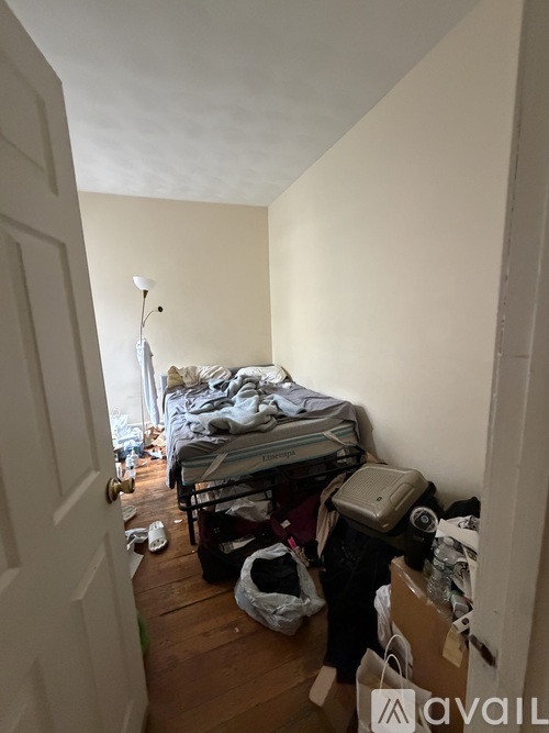 A messy room with a bed and a chair in it.
