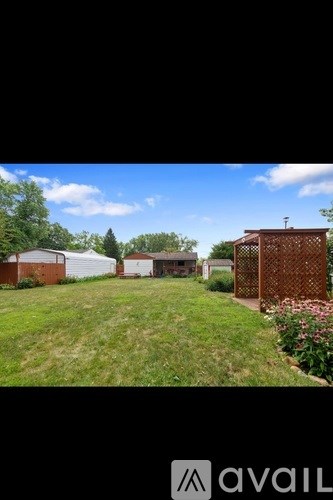 A grassy yard with a fence and a building in the background.