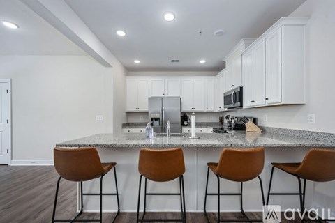 A kitchen with white cabinets and a granite countertop.