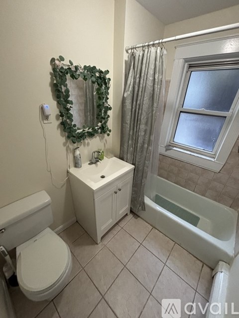 A bathroom with a toilet, sink, and bathtub.
