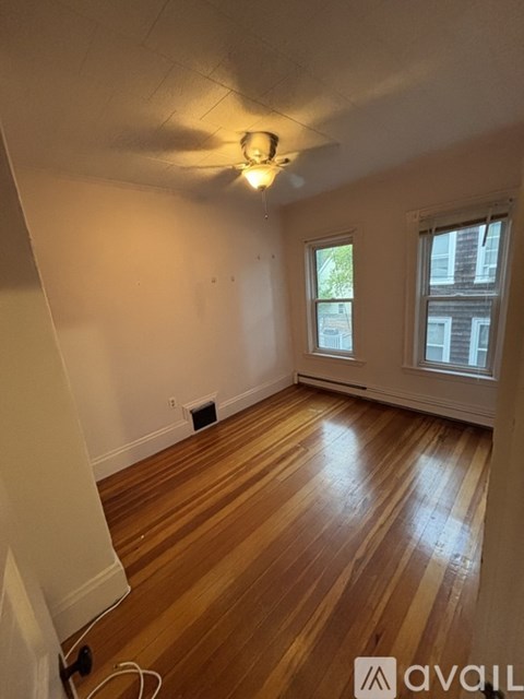 A room with wooden floors and a ceiling fan.