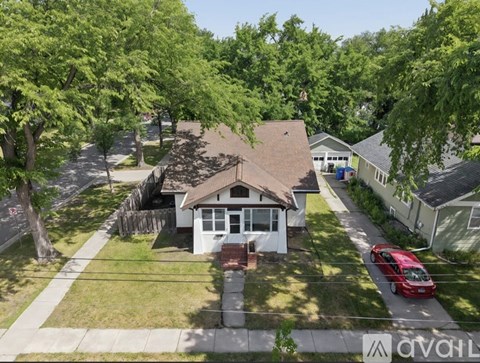 A house with a red car parked in front.