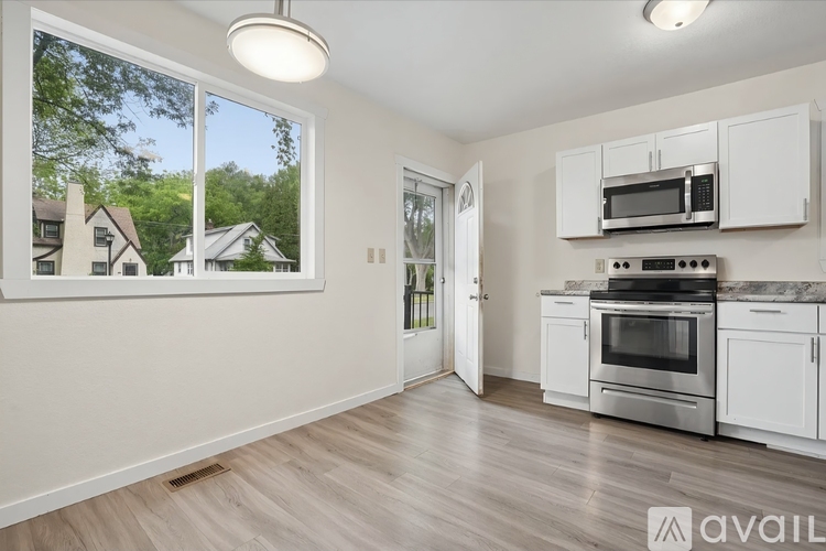 A kitchen with white cabinets and a microwave above the stove.