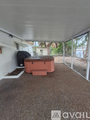 A hot tub sits in the middle of a covered patio area.