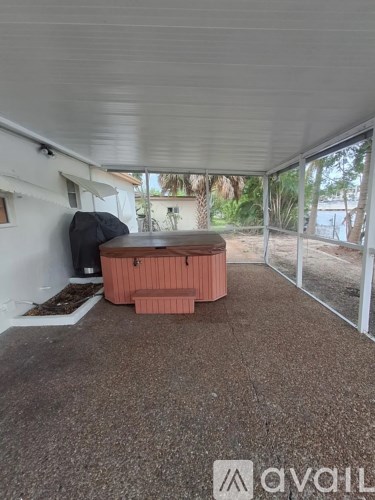 A hot tub sits in the middle of a covered patio area.
