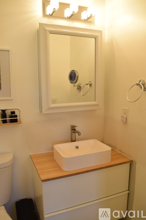 A bathroom with a white sink and a mirror above it.