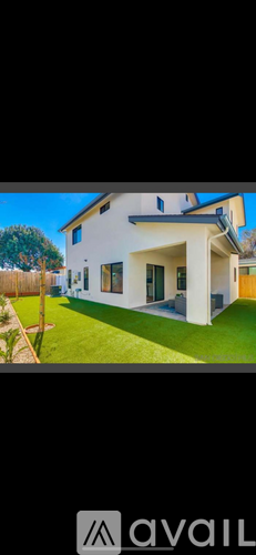 A modern house with a white exterior and a large front yard.