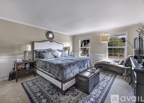 A bedroom with a large bed and a window with a view of trees.