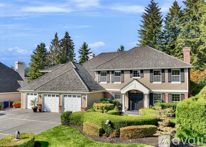 A large house with a grey roof and a garage door.