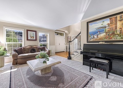 A living room with a couch, a coffee table, and a painting on the wall.