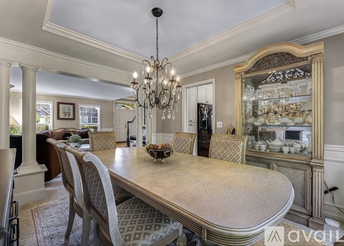 A dining room with a large table and chairs.