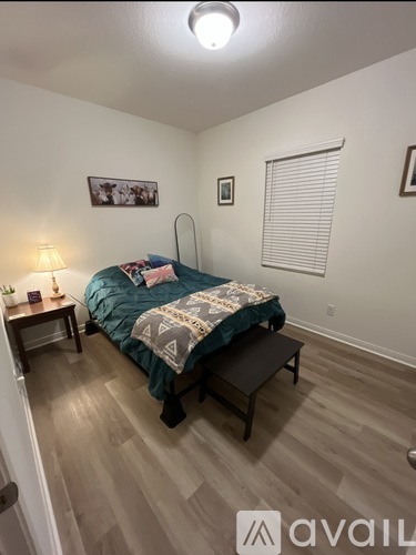 A bedroom with a bed, nightstand, and lamp.