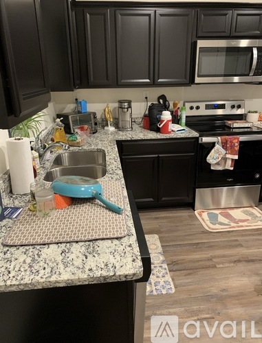 A kitchen with black cabinets and a granite countertop.