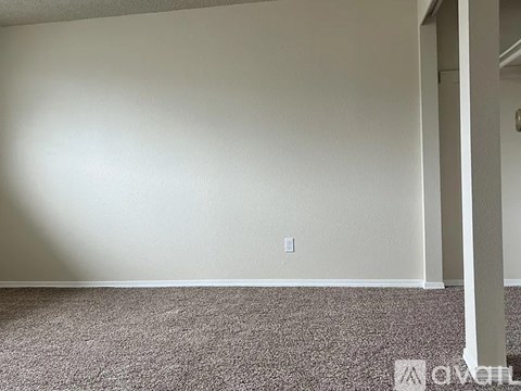 A room with a carpeted floor and a white wall.
