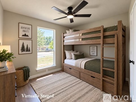 A room with a white door and wooden flooring.