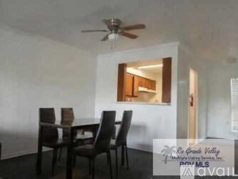 A dining room with a table and chairs and a ceiling fan.