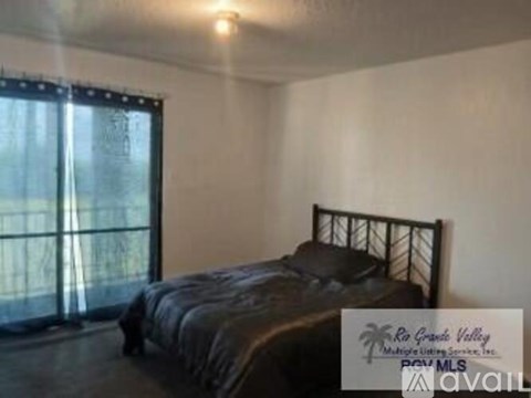 A bedroom with a bed and a window with blinds.