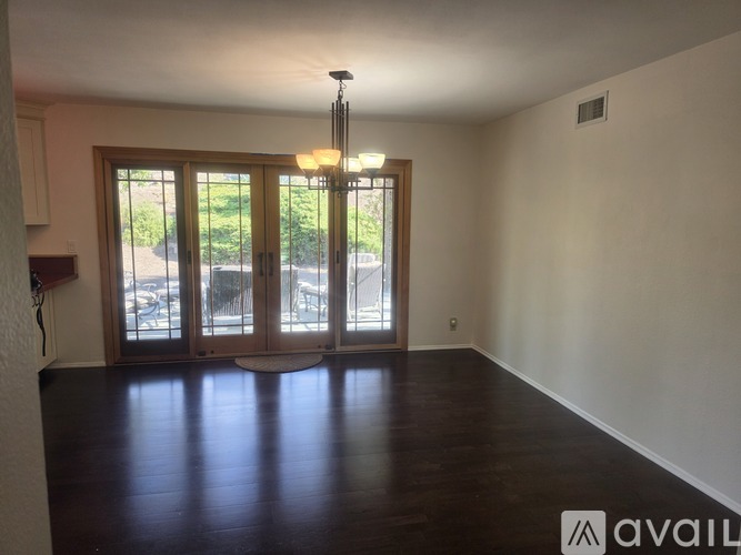 A room with wooden floors and a chandelier.