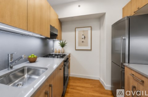 A kitchen with wooden cabinets and a stainless steel refrigerator.