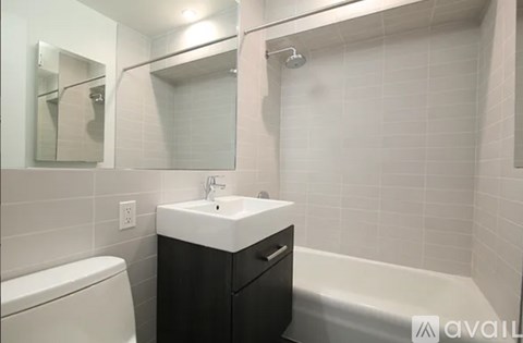 A bathroom with a white sink and black cabinet.
