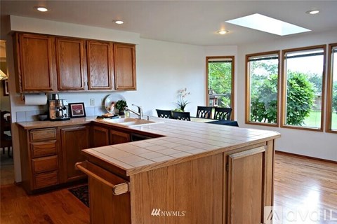 A kitchen with wooden cabinets and a large island.