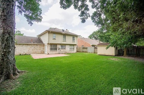 A house with a large lawn and trees in front.