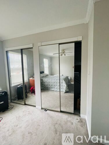 A bedroom with a bed and a mirror on the wall.