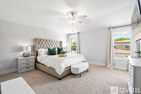 A well-lit bedroom with a large bed and a window overlooking a balcony.