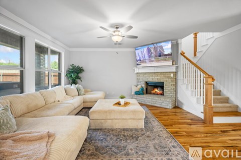 A living room with a white couch and a fireplace.