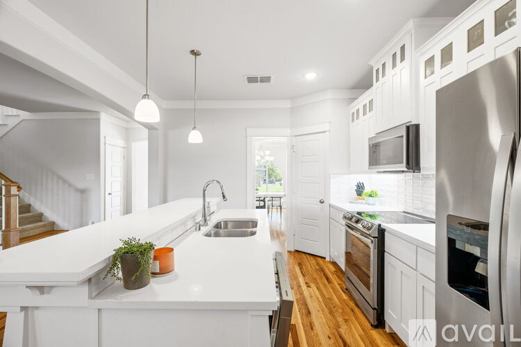 A modern kitchen with white cabinets and stainless steel appliances.