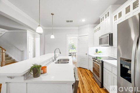 A modern kitchen with white cabinets and stainless steel appliances.