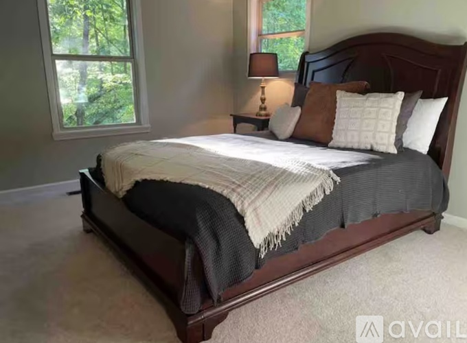 A bedroom with a large bed and a window.
