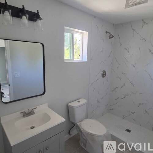 A bathroom with a marble wall and a toilet.