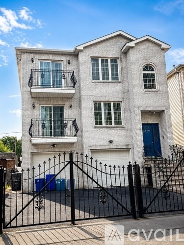 A two-story house with a black gate in front.