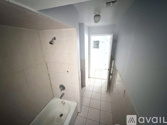 A bathroom with a white bathtub and tiled floor.