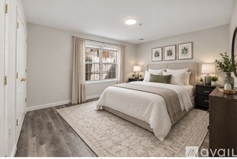 A bedroom with a large bed, a window with curtains, and a wooden dresser.
