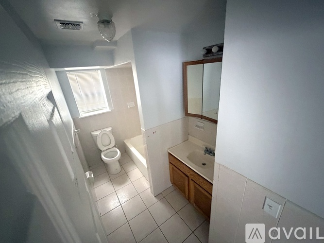 A bathroom with a toilet, sink, and mirror.