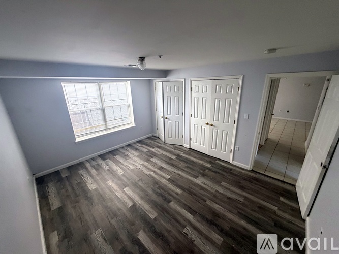 A room with wooden flooring and white doors.