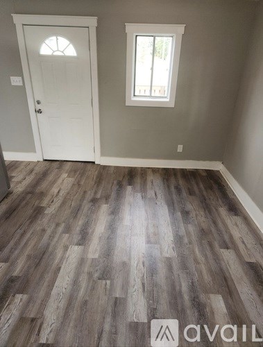 A room with a wooden floor and a white door.