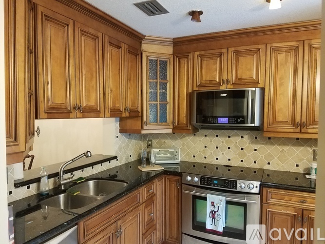 A kitchen with wooden cabinets and a black countertop.
