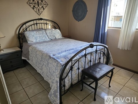 A bedroom with a bed, chair, and wall decorations.