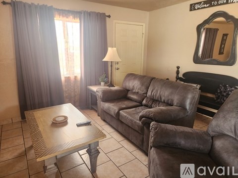 A living room with a brown leather couch and a wooden coffee table.