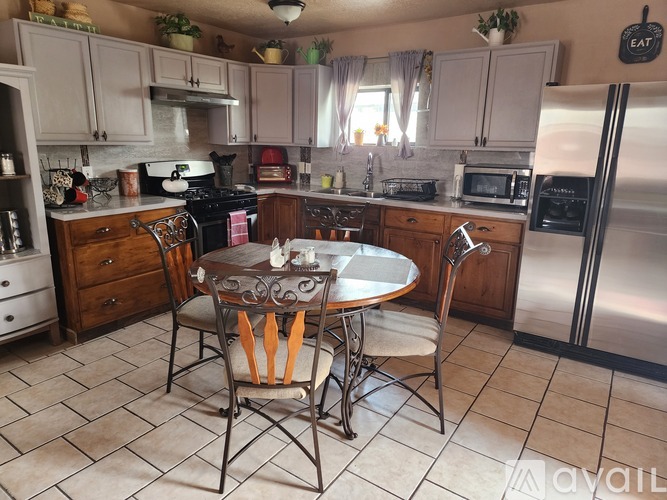 A kitchen with a table and chairs in the middle.