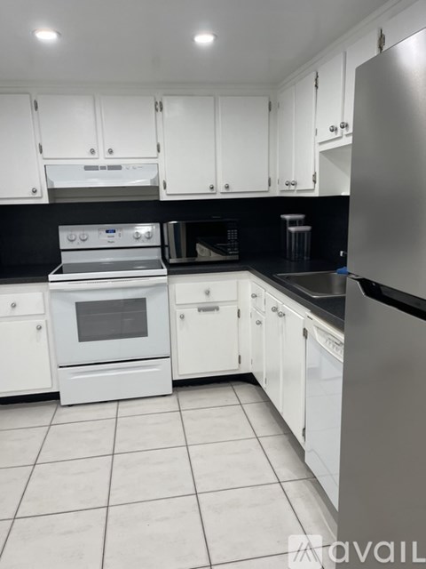 A kitchen with white cabinets and appliances.
