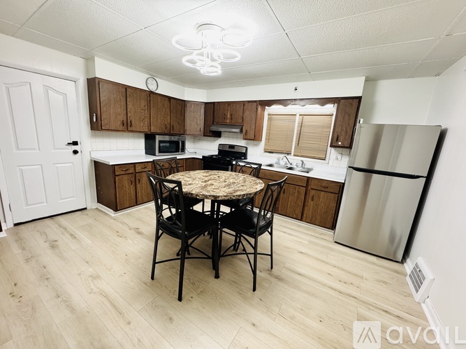 A kitchen with a table and chairs in the middle.