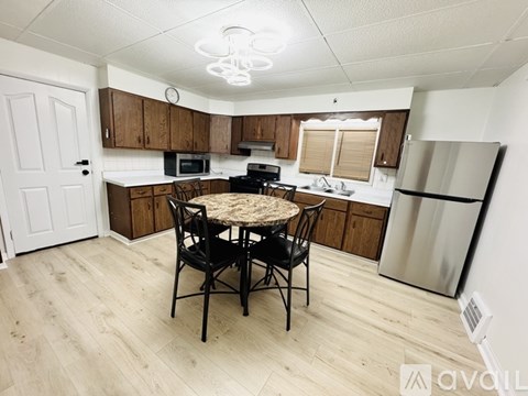 A kitchen with a table and chairs in the middle.