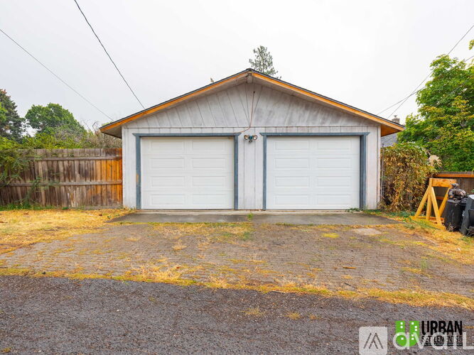 A two-car garage with a wooden fence in front.