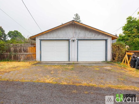A two-car garage with a wooden fence in front.